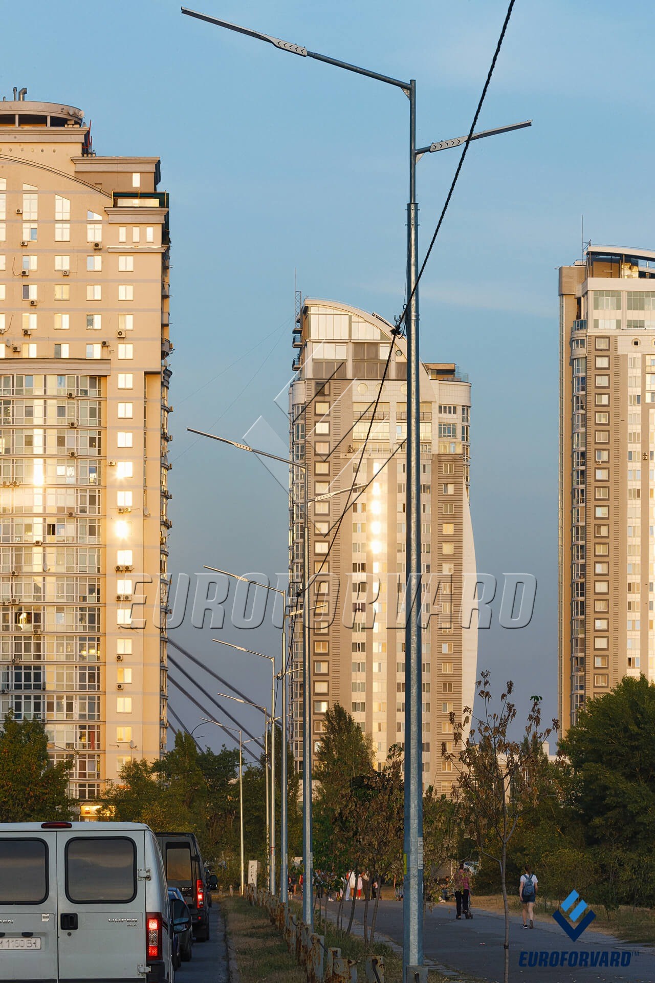 Опори вуличного освітлення в місті на фоні високі будинки
