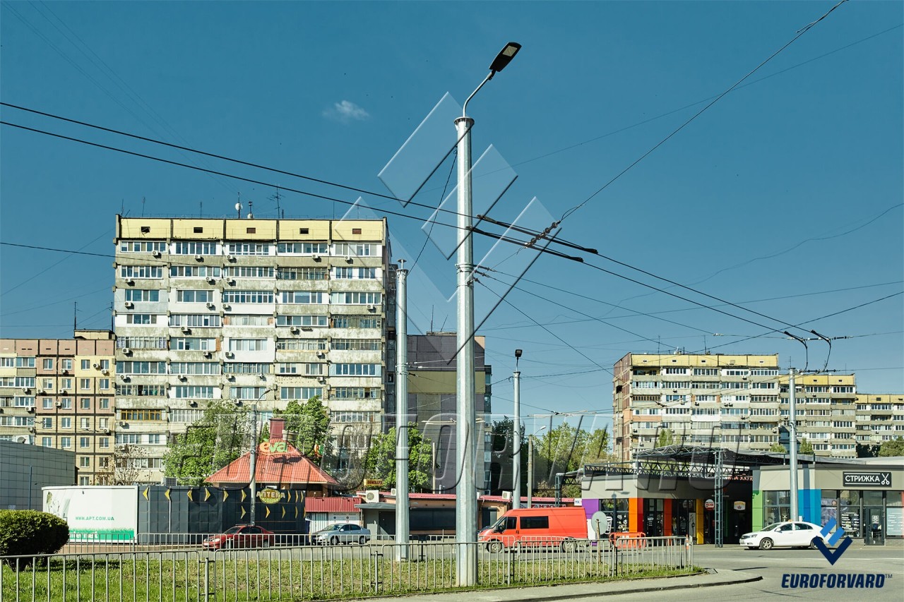 Опоры контактной сети металлические возле проезжей части в городе днем