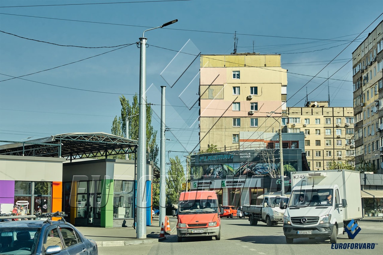 Опоры контактной сети металлические возле дороги и зданий в городе