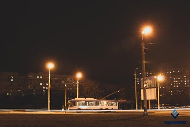 Опоры контактной сети городского электротранспорта возле дороги в темноте