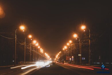 Опоры контактной сети городского электротранспорта вдоль дороги в темноте