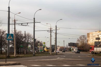 Опоры контактной сети городского электротранспорта возле дороги днем