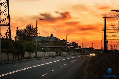 Опоры уличного освещения металлические на фоне заката солнца