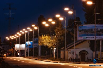 Опоры уличного освещения металлические в темноте возле дороги
