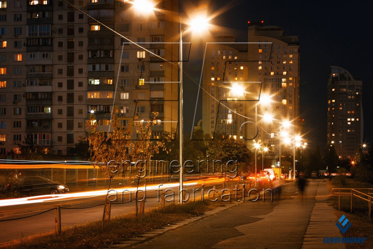 Опоры уличного освещения на улице города возле высоких зданий