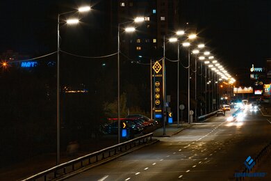 Опоры уличного освещения возле дороги в темноте с яркими фонарями