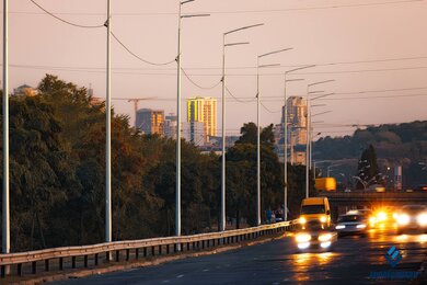 Опоры уличного освещения в городе на фоне вечернего неба