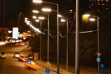 Опоры уличного освещения на фоне автотрафика в городе
