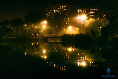 Опоры уличного освещения на фоне озера в городе