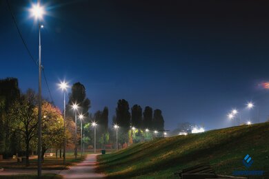 Опоры уличного освещения возле пешеходных дорожек в сумерках
