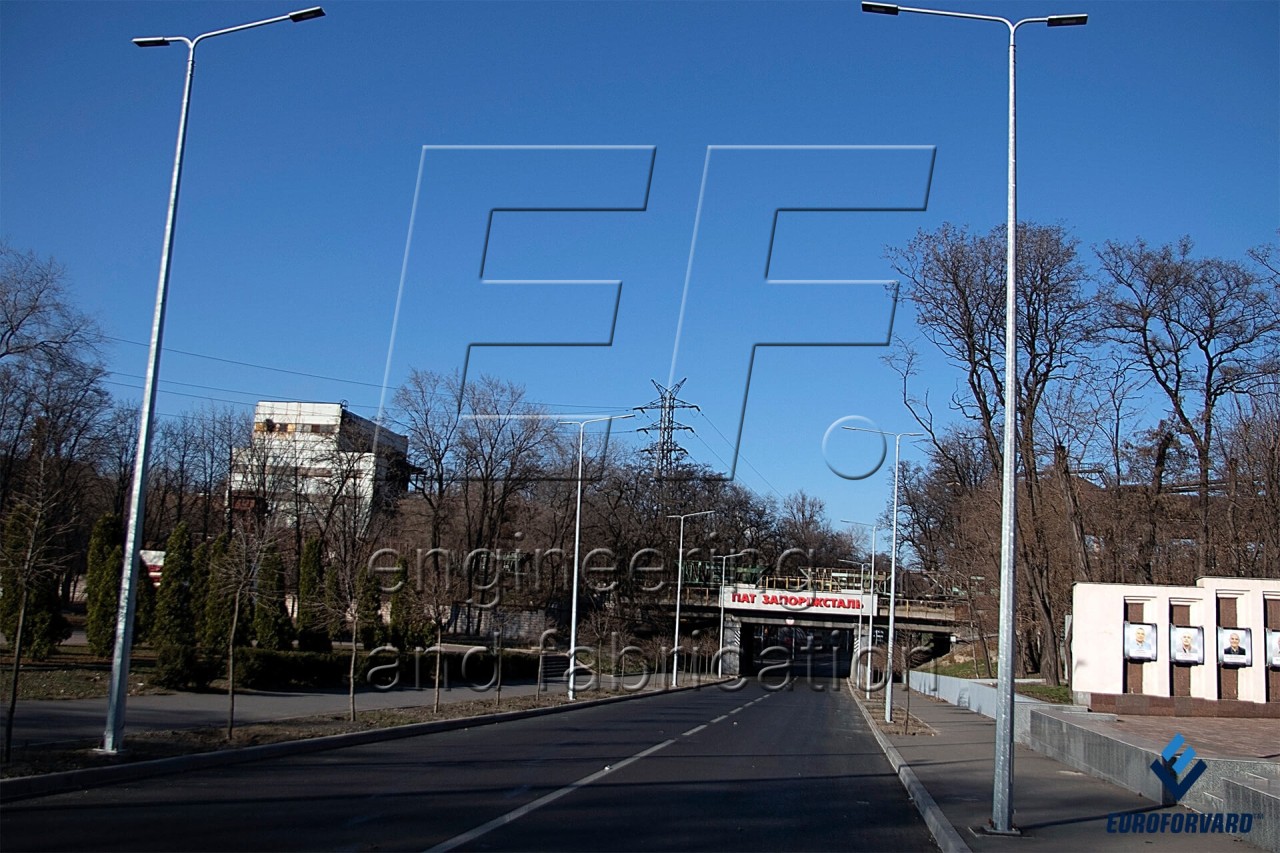 Опоры уличного освещения рядом с железнодорожным мостом