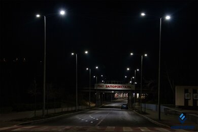 Опоры уличного освещения рядом с железнодорожным мостом ночью