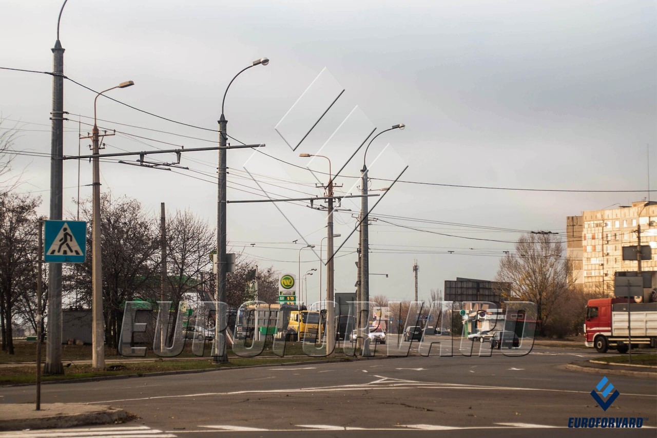 Опори контактної мережі міського електротранспорту біля дороги вдень