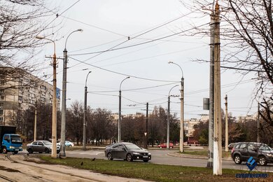 Опори контактної мережі міського електротранспорту з світильниками вздовж дороги