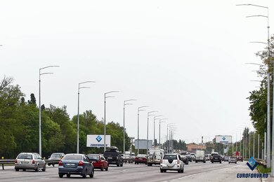 Силовые опоры освещения вдоль автомобильной магистрали днем