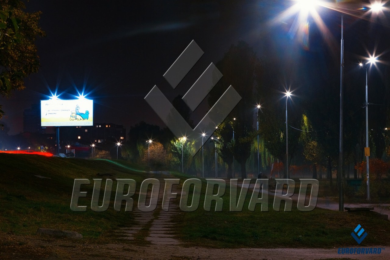 Опори вуличного освітлення біля пішохідної доріжки в темряві