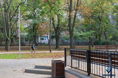 Опори паркового освітлення біля лавок у сквері