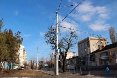 Опоры крепления контактной сети днем возле дороги