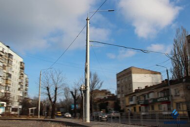Опоры контактной сети днем возле автодороги