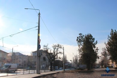 Опоры контактной сети днем возле городской дороги