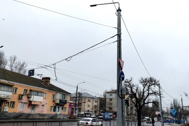Опоры крепления контактной сети днем возле городской дороги