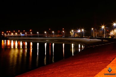 Опоры уличного освещения на набережной в темноте