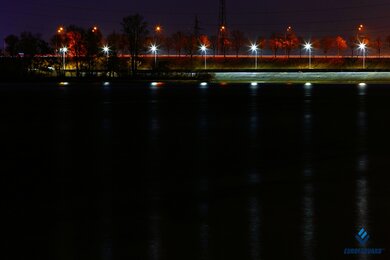 Опоры уличного освещения вдоль набережной в темноте