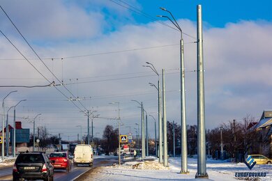 Опори контактної мережі фланцеві біля проїжджої частини в місті вдень