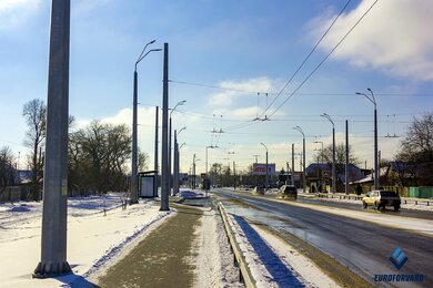 Опори контактної мережі фланцеві вздовж проїжджої частини в місті вдень