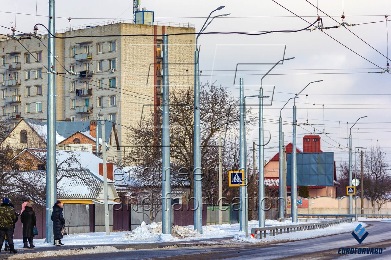 Опоры контактной сети фланцевые возле дороги в городе днем