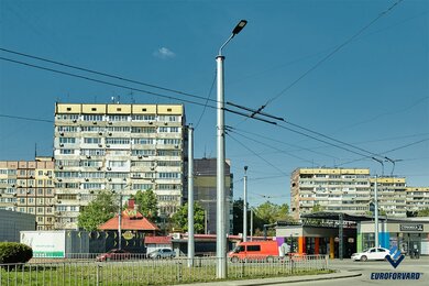 Опори контактної мережі металеві біля проїжджої частини в місті вдень