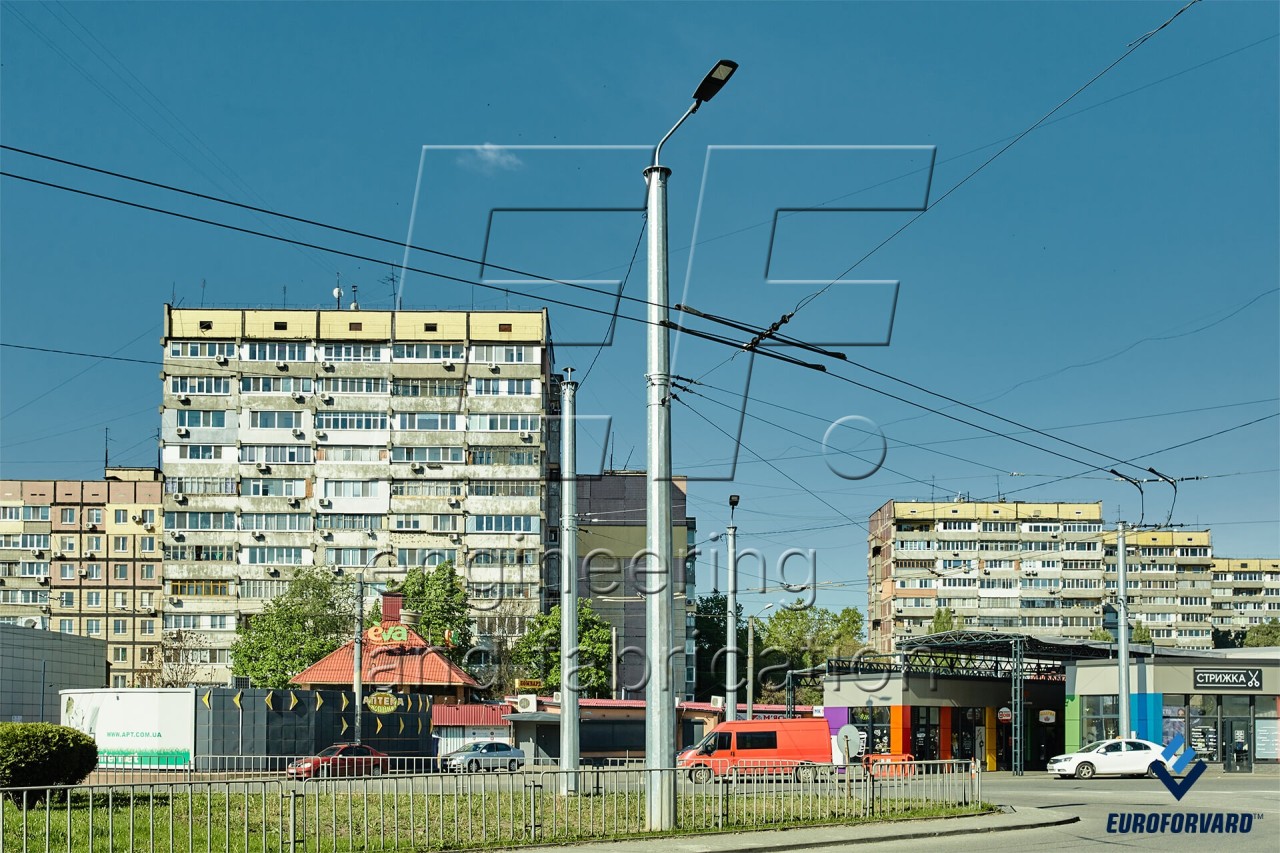 Опоры контактной сети металлические возле проезжей части в городе днем
