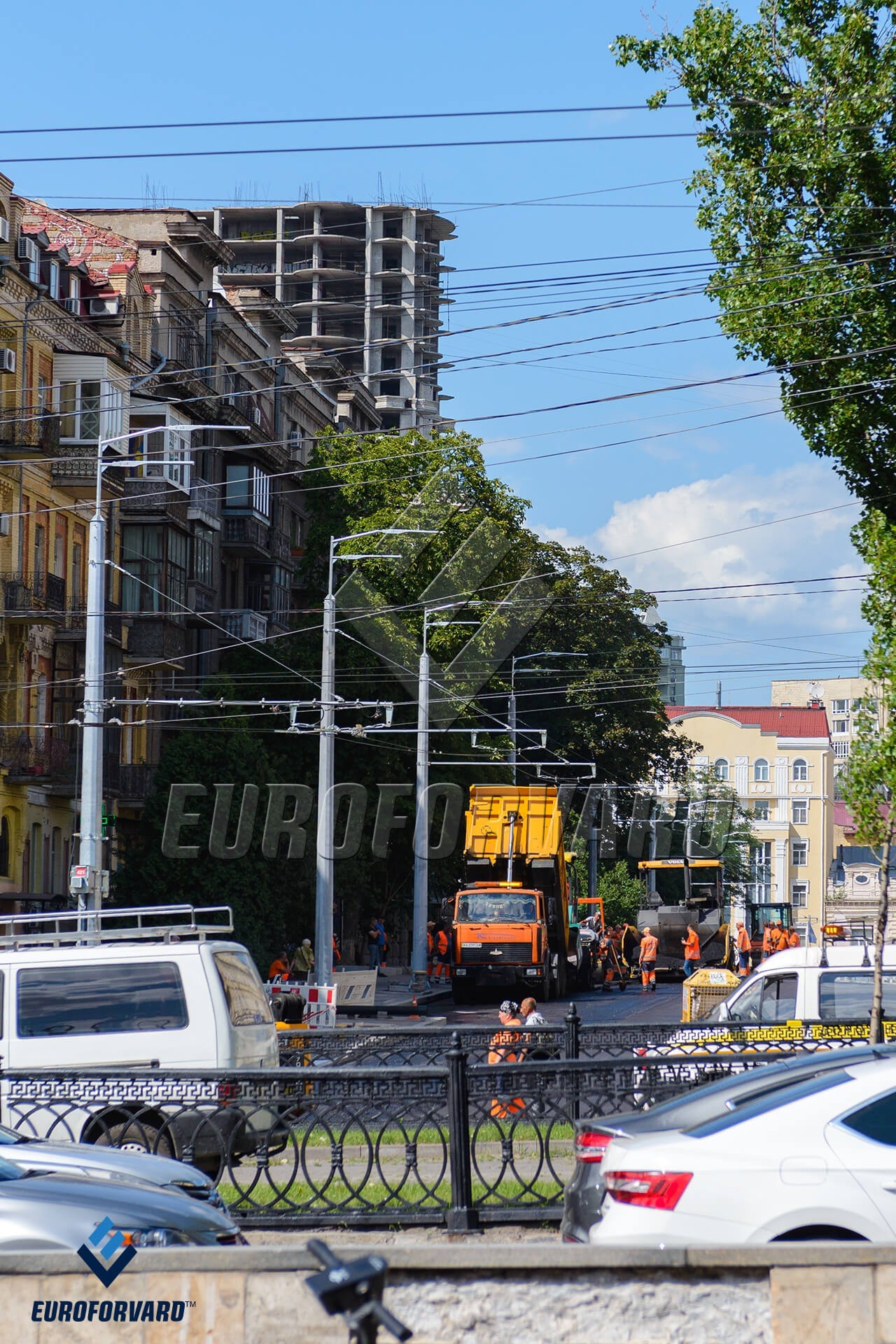 Опори контактної мережі вздовж міської дороги поруч з будівлями