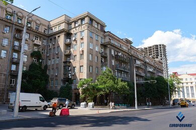 Опори контактної мережі біля дороги на фоні будівель