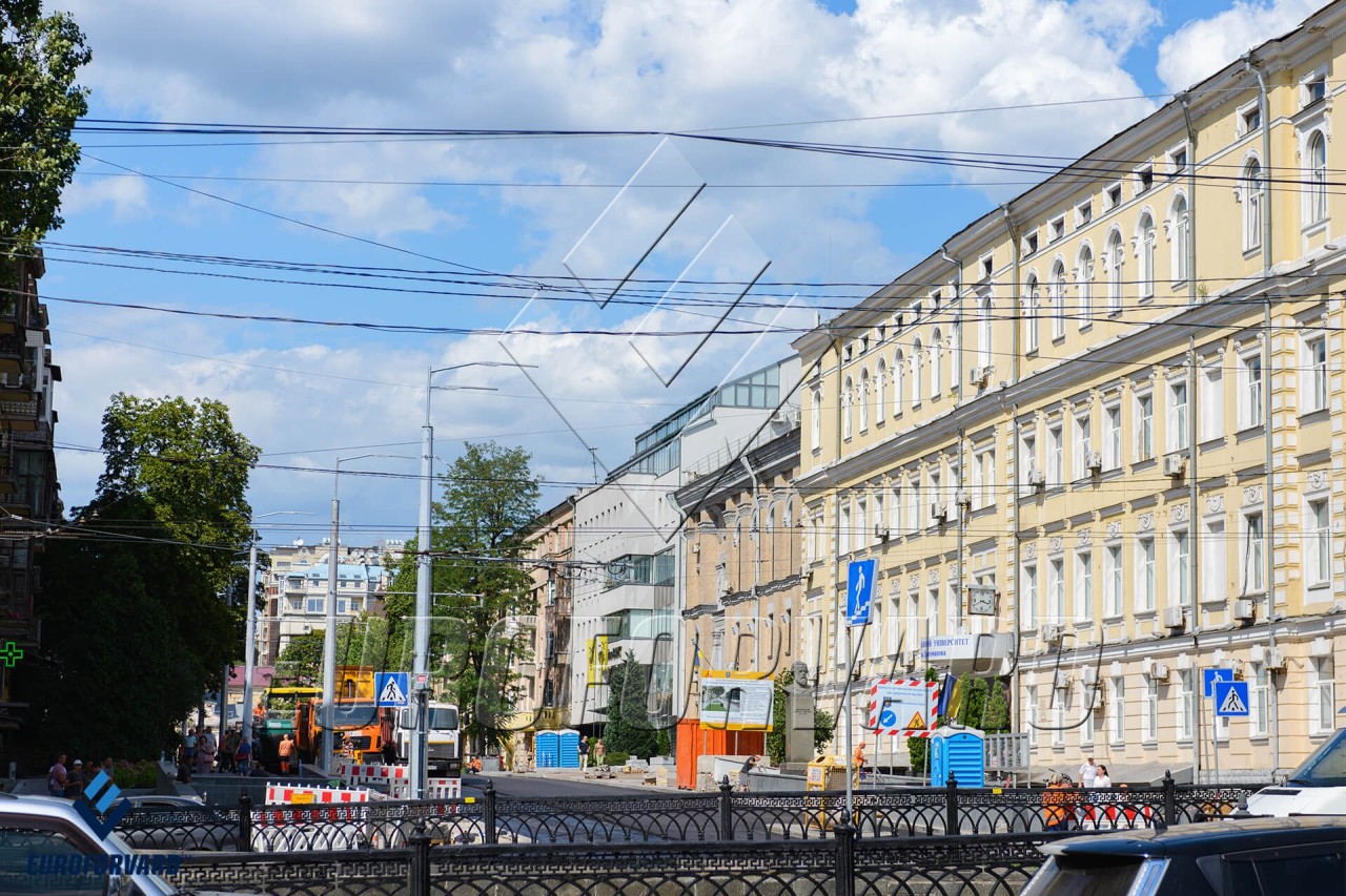 Опори контактної мережі на тротуарі біля міської дороги та будівель