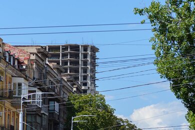 Опоры контактной сети вдоль городской дороги рядом со зданиями