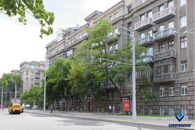 Опоры контактной сети возле дороги и зданий в городе