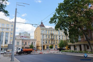 Опоры контактной сети рядом с дорогой и городскими зданиями