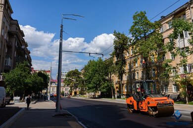 Опоры контактной сети на тротуаре возле дороги в городе