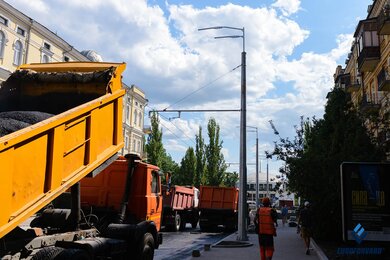Опоры контактной сети на тротуаре вдоль городской дороги