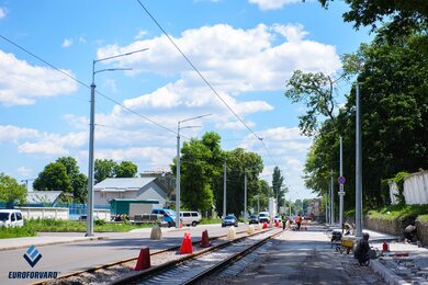 Опори контактної мережі вздовж міської вулиці з трамвайними коліями