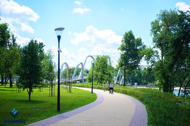 Опори паркового освітлення на фоні пішохідного мосту