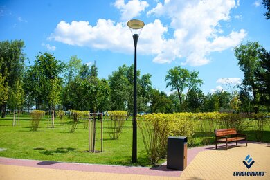 Опори паркового освітлення біля лавок у парку