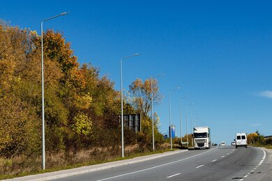 Опори вуличного освітлення вздовж автомобільної магістралі вдень