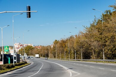 Опоры уличного освещения вдоль магистрали днём