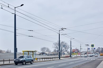 Опори контактної мережі з кронштейнами вздовж міської дороги