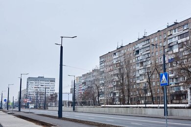 Опори контактної мережі з кронштейнами вздовж вулиці міста вдень