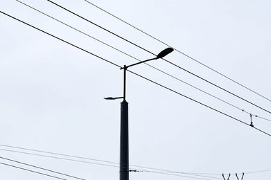 Опори контактної мережі з кронштейнами на вулиці міста вдень