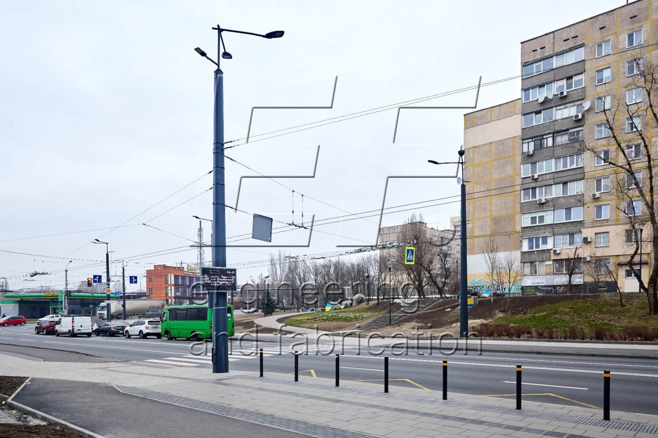 Опори контактної мережі з кронштейнами біля дороги в місті