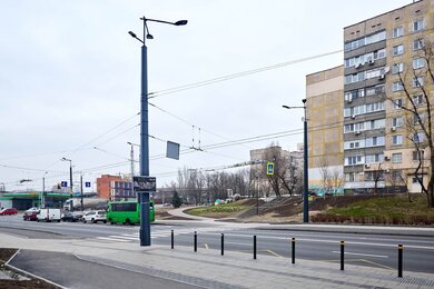Опори контактної мережі з кронштейнами біля дороги в місті